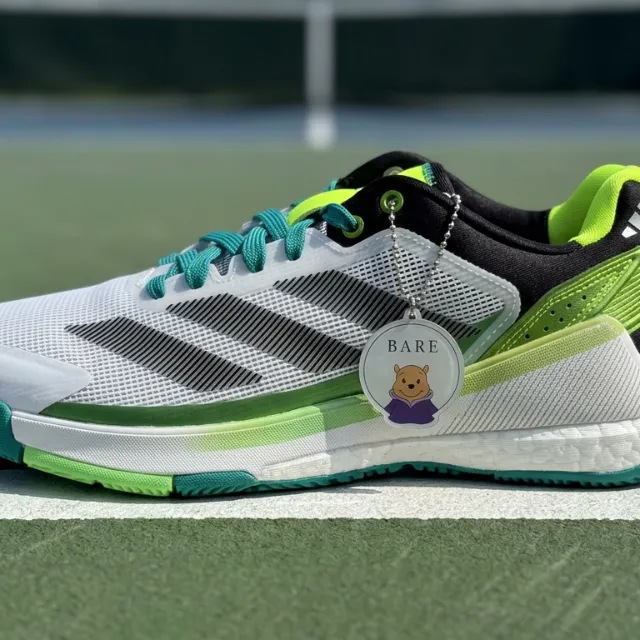 Adidas tennis shoe on a hard-court baseline